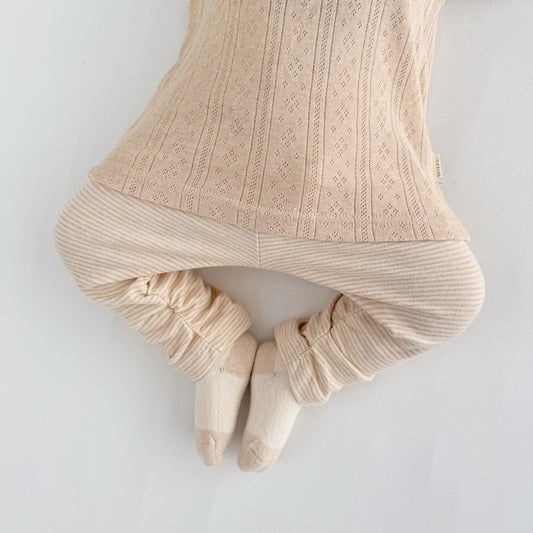 Close up look at the fancy elastic ruffle side baby girl tights stitching on soft cotton fabric.