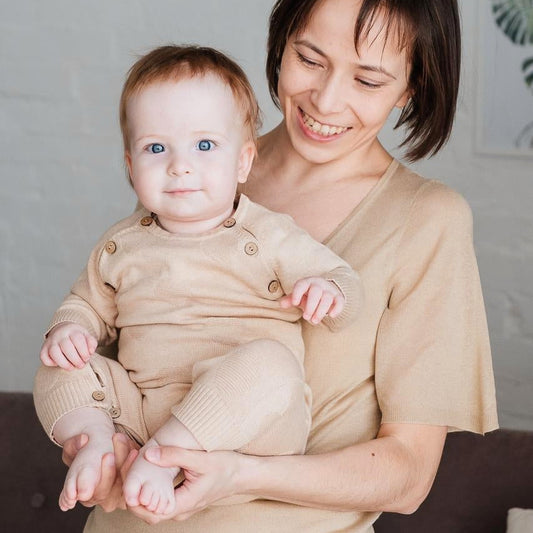 Lightweight organic cotton baby summer romper showing an embossed star motif and shoulder coconut buttons