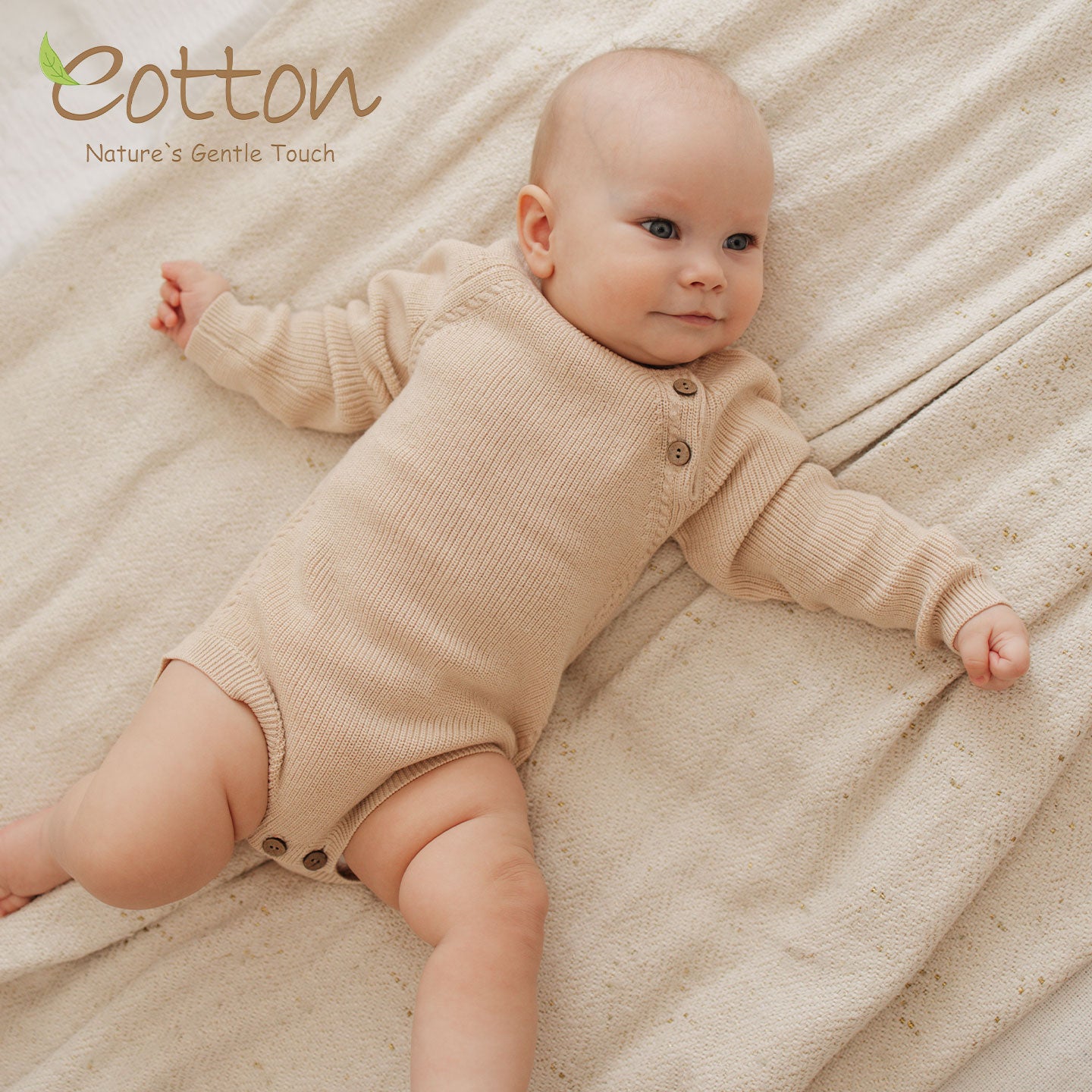 Baby lying on blanket wearing an organic cotton ribbed knit baby sweater onesie with shoulder coconut buttons