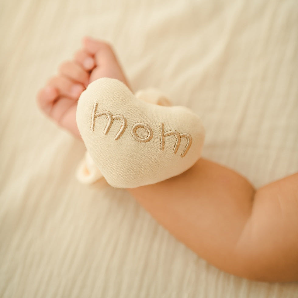 organic newborn wrist rattle in heart shape worn on baby arm
