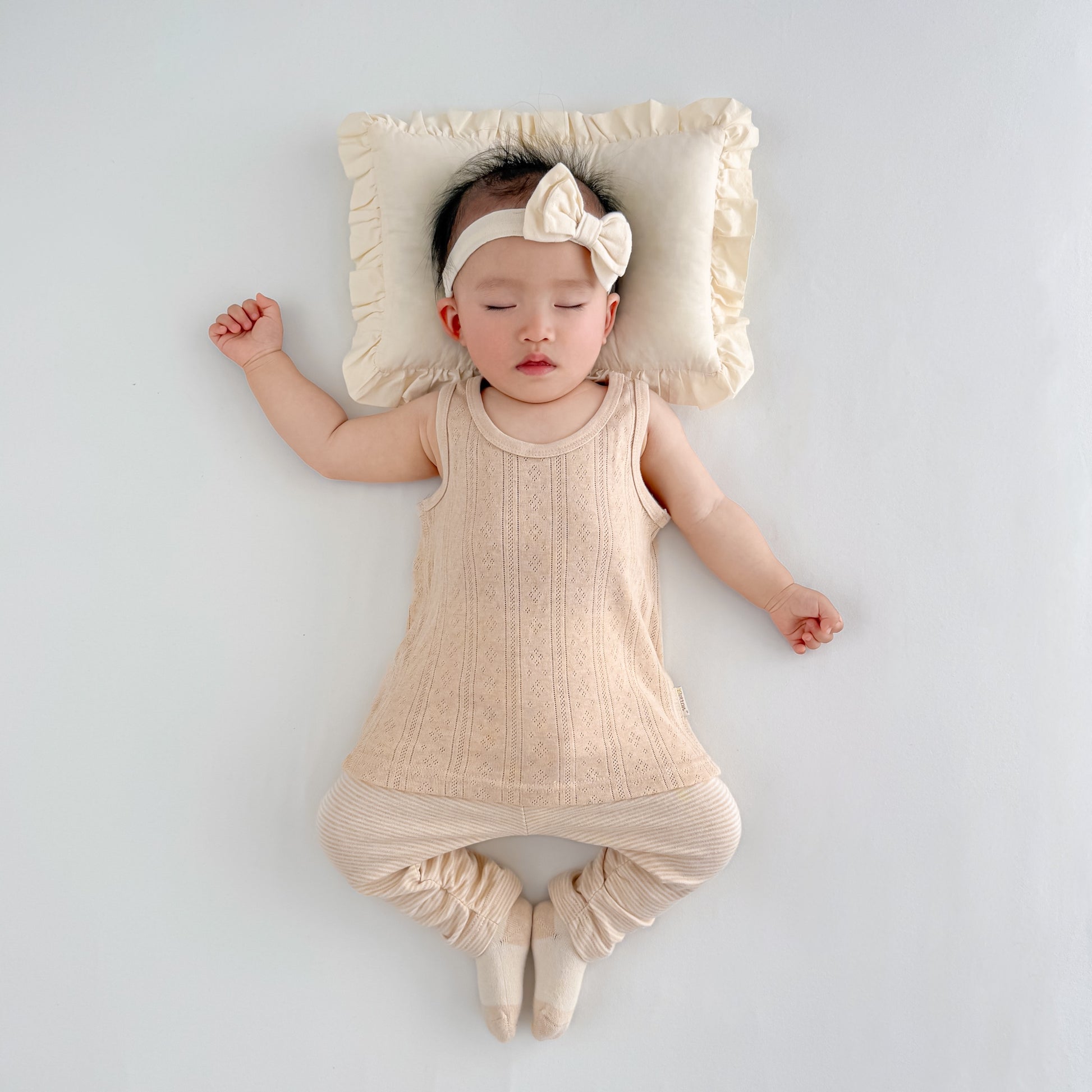 All season unbleached striped baby girl pants styled nicely under a light summer dress overlay.