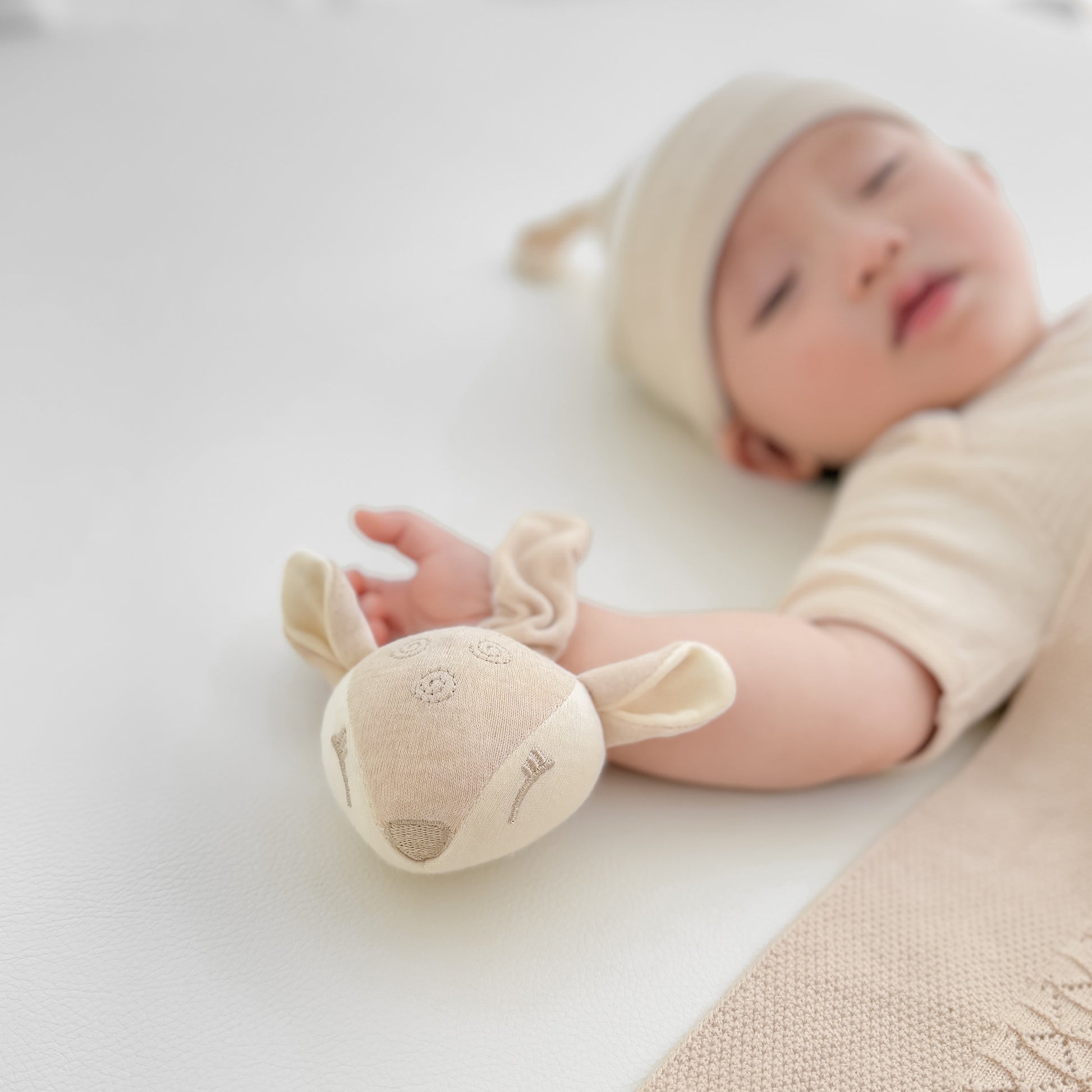 Close up view of a Japan JFSL tested safe organic sensory toy wrist rattle made from dye-free nature colored cotton | Eotton Canada