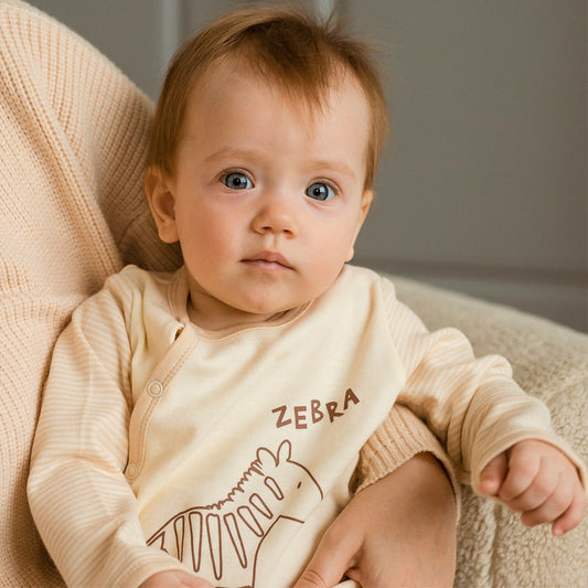 Organic footie French romper with curved side snaps in high-contrast zebra print