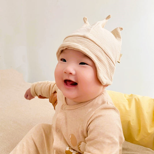 Cutest baby hat in premium unbleached organic cotton worn by a happy smiling newborn.