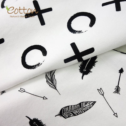 Close up texture view of the silky smooth and stretchy organic combed cotton weave on a black and white infant receiving blanket.