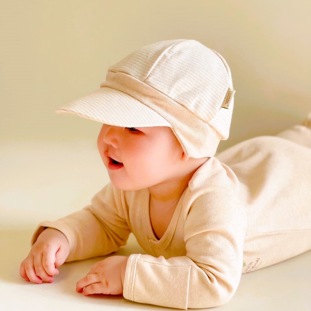 Organic cotton all season baby hat showcasing a flexible soft sun brim and comfortable ear shading.