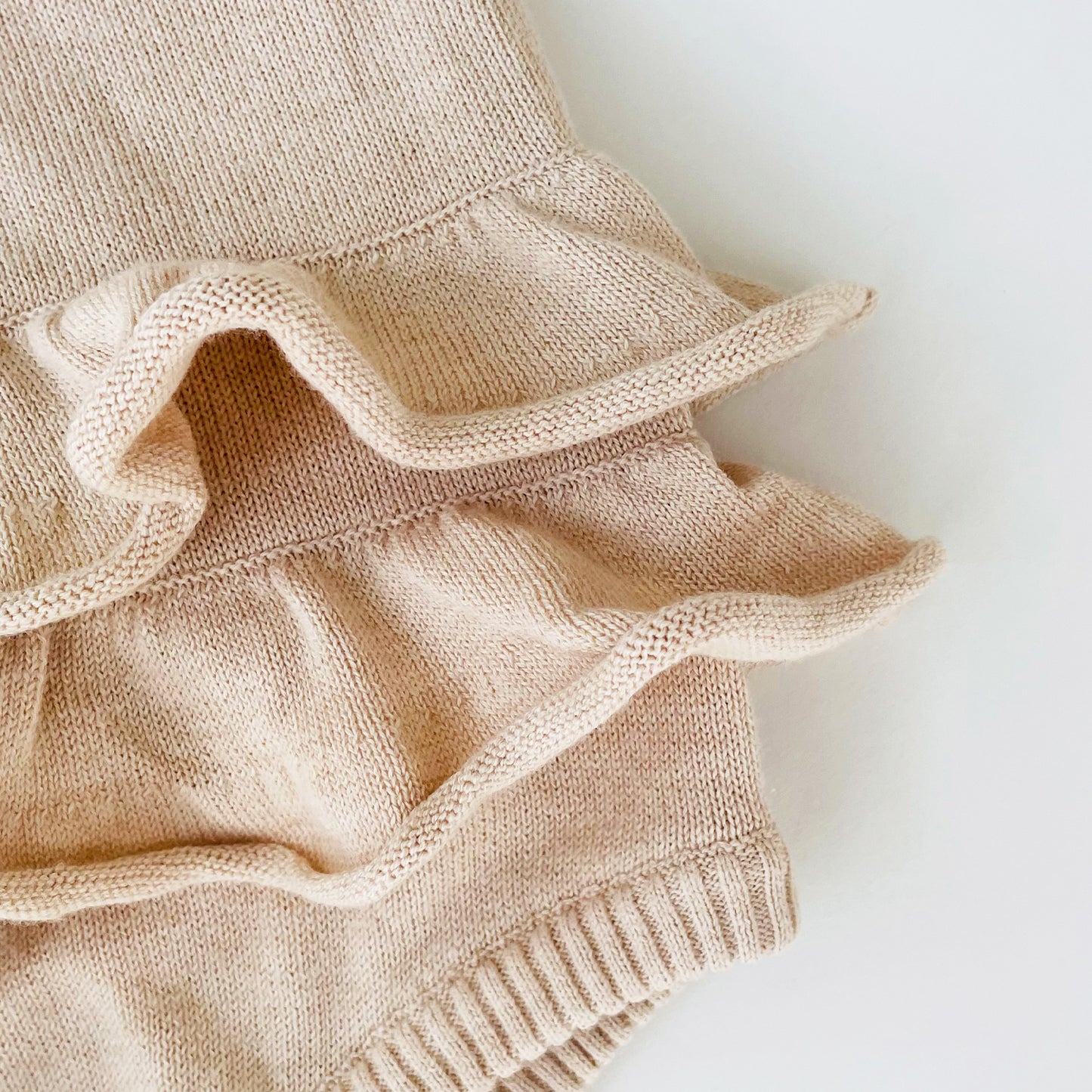 detail of the organic nature colored combed cotton fine knit baby ruffle  onesie 