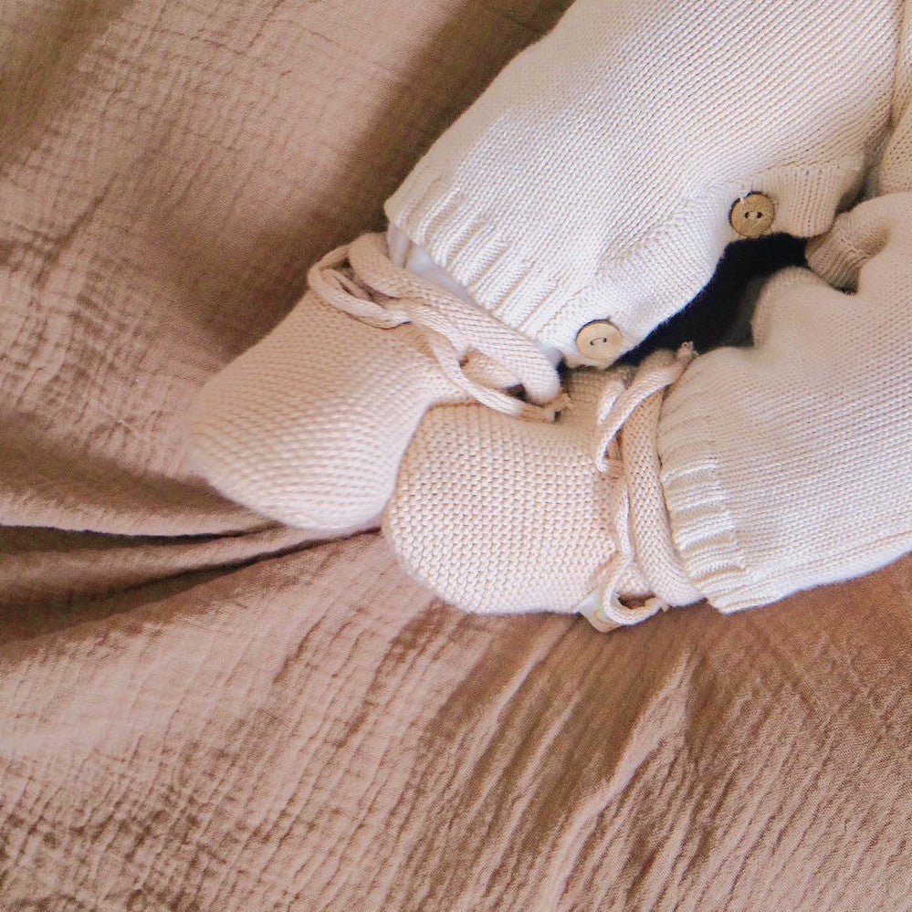 Detail of the foldover ribbed cuff that helps knitted booties stay on newborn feet | Eotton Canada